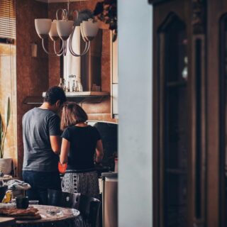 man and woman standing in front of gas range